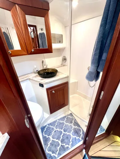 Reel Life Yacht Photos Pics Luxurious bathroom in 2015 Jupiter 41SB yacht with modern fixtures and elegant wood cabinetry.