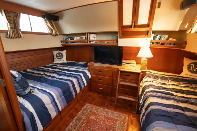 Moonshadow Yacht Photos Pics Cozy cabin interior of 1985 Grand Banks 42 Classic yacht with twin beds and wooden furnishings.