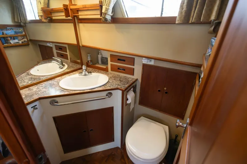 Moonshadow Yacht Photos Pics 1985 Grand Banks 42 Classic yacht bathroom with sink, toilet, and wooden cabinetry.