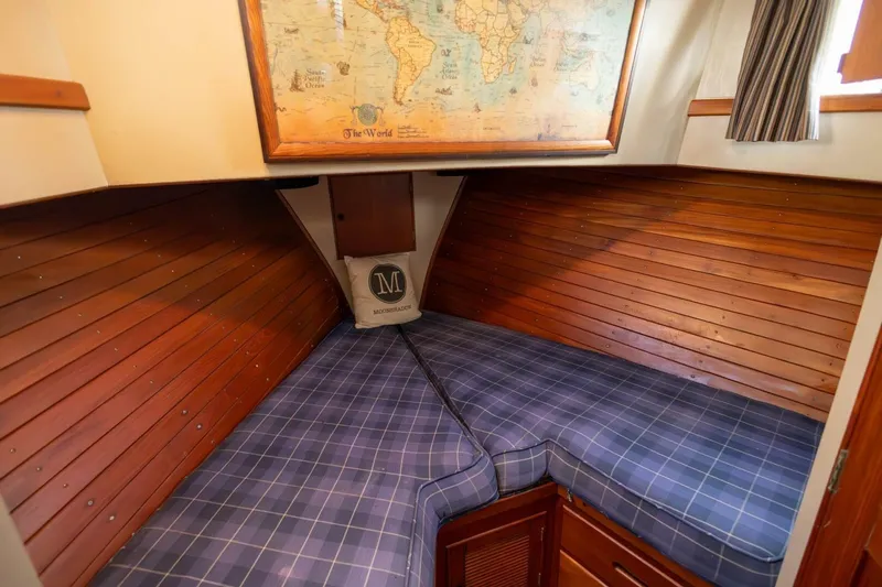 Moonshadow Yacht Photos Pics Cozy cabin interior of 1985 Grand Banks 42 Classic with plaid bedding and world map decor.