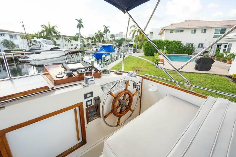 Moonshadow Yacht Photos Pics Cockpit of 1985 Grand Banks 42 Classic yacht with wooden steering wheel and marina view.