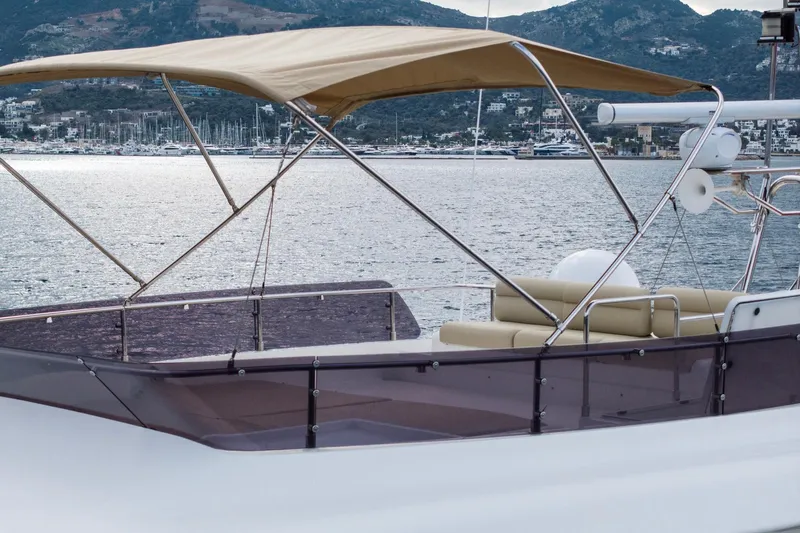  Yacht Photos Pics Luxurious 2014 Custom Line Navetta 26 Crescendo yacht with canopy, docked by scenic coastline.