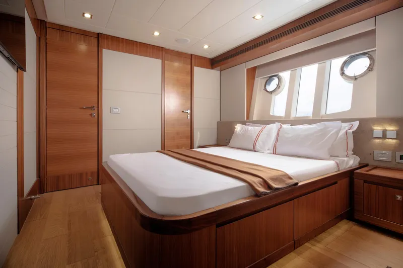  Yacht Photos Pics Luxurious bedroom interior on 2014 Custom Line Navetta 26 Crescendo yacht, featuring elegant wood finishes.