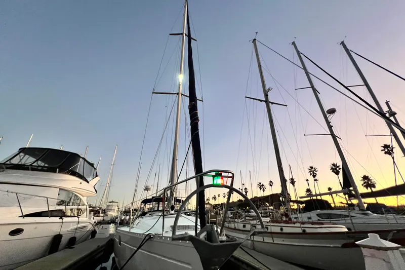 Alpha Carina Yacht Photos Pics 1993 Beneteau Oceanis 440 sailboat docked at sunset, surrounded by other yachts.