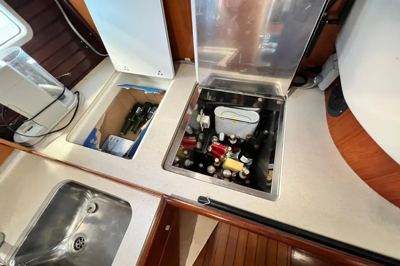 Alpha Carina Yacht Photos Pics Kitchen area of 1993 Beneteau Oceanis 440 with built-in storage and sink.