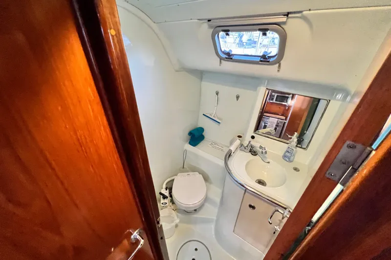 Alpha Carina Yacht Photos Pics Bathroom interior of 1993 Beneteau Oceanis 440 yacht, featuring sink and toilet.