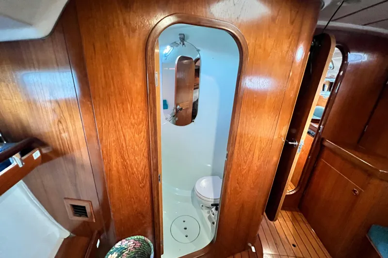 Alpha Carina Yacht Photos Pics Interior of 1993 Beneteau Oceanis 440 yacht showing wooden cabin and compact bathroom.