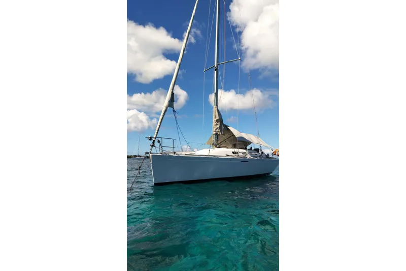  Yacht Photos Pics Beneteau First 40.7 sailboat from 2004 on clear blue water under a sunny sky.