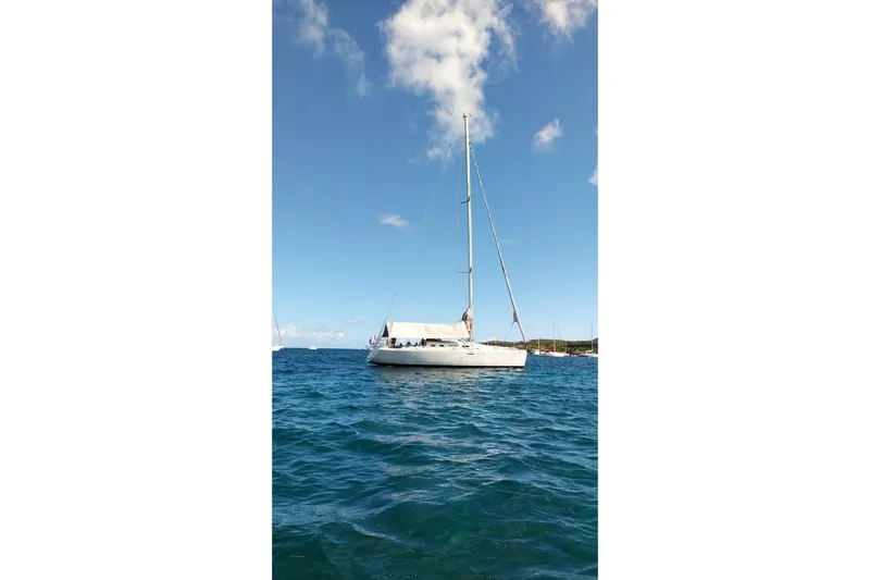  Yacht Photos Pics 2004 Beneteau First 40.7 sailboat on clear blue ocean under a bright sky.