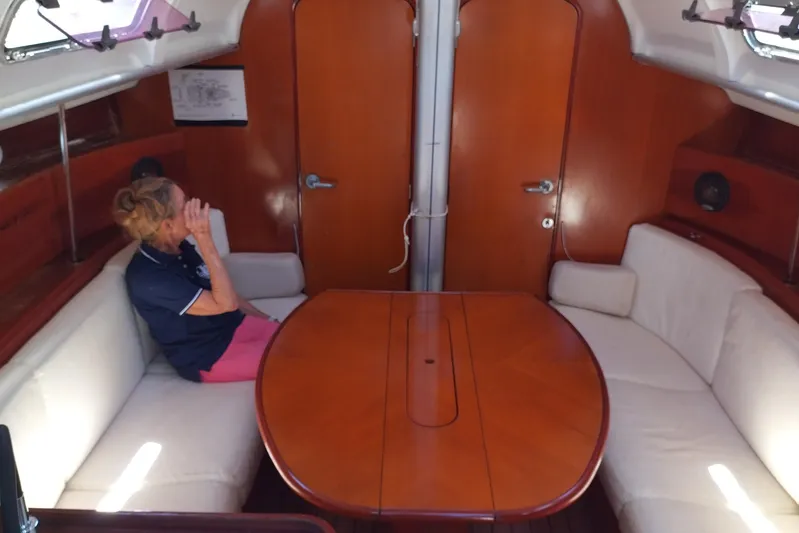  Yacht Photos Pics Interior of 2004 Beneteau First 40.7 sailboat with wooden table and seating area.