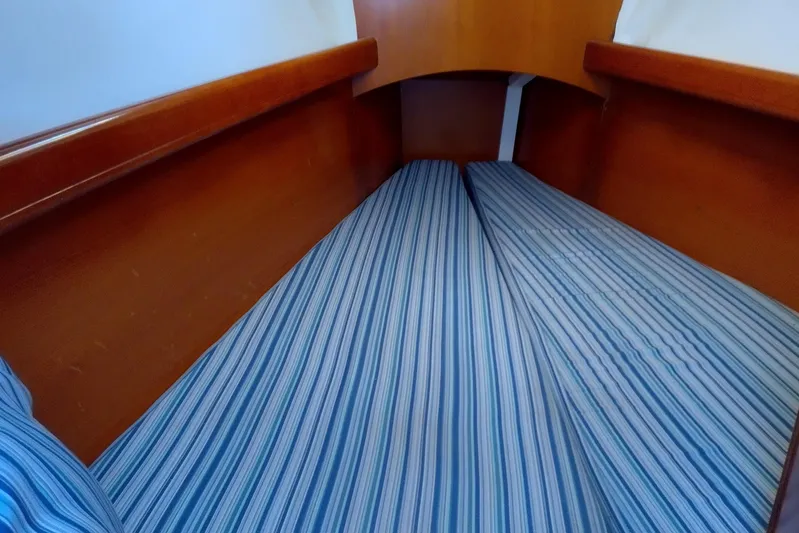  Yacht Photos Pics Interior cabin of 2004 Beneteau First 40.7 with striped bedding and wooden finish.