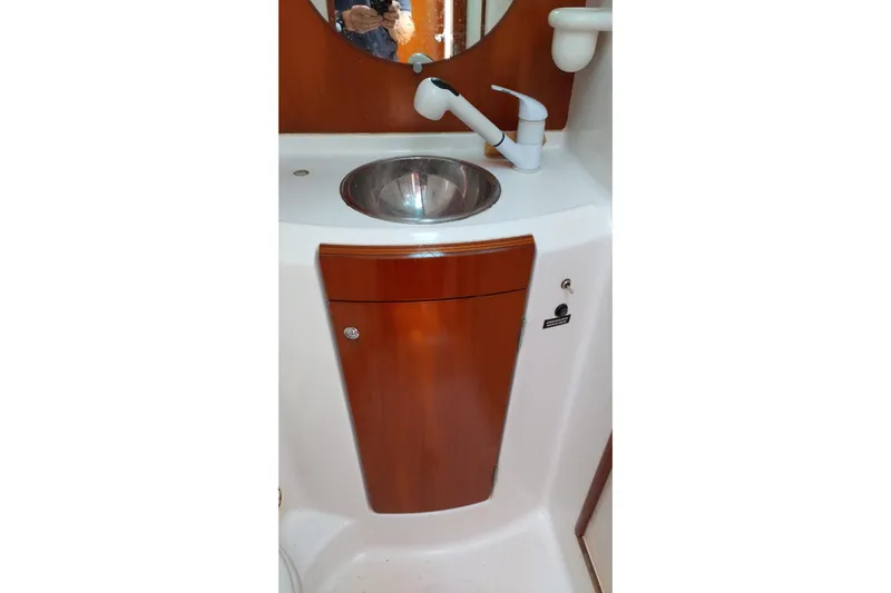  Yacht Photos Pics Beneteau First 40.7 2004 yacht bathroom sink with wooden cabinet and mirror.