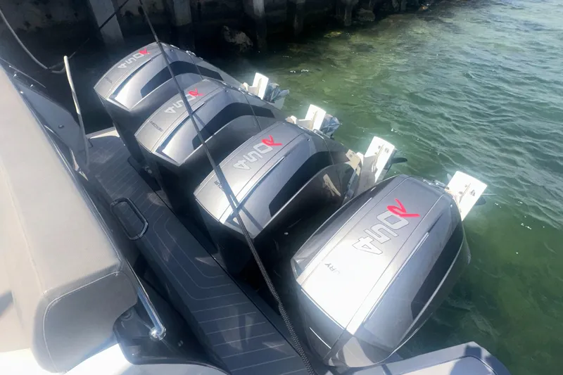  Yacht Photos Pics Four powerful outboard engines on a 2021 Azimut Verve 47 boat, docked in clear water.
