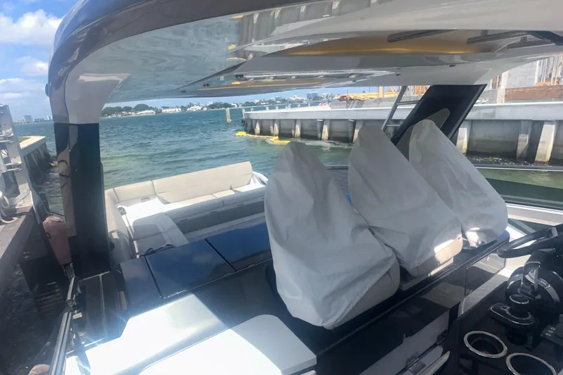  Yacht Photos Pics 2021 Azimut Verve 47 luxury yacht interior at dock, featuring covered seating and helm.
