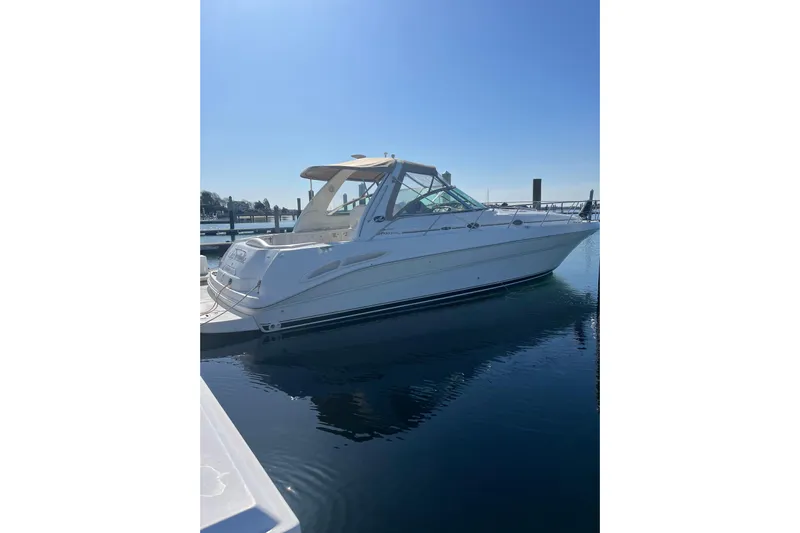 Cap'n Belle Yacht Photos Pics 2002 Sea Ray 410 Sundancer yacht docked in a serene marina setting.