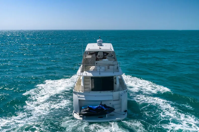  Yacht Photos Pics Luxury 2005 Marquis 59 yacht cruising on open sea with jet ski onboard.