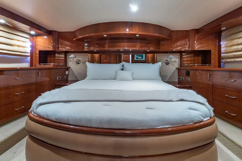  Yacht Photos Pics Luxurious 2005 Marquis 59 yacht bedroom with elegant wood finishes and plush bedding.