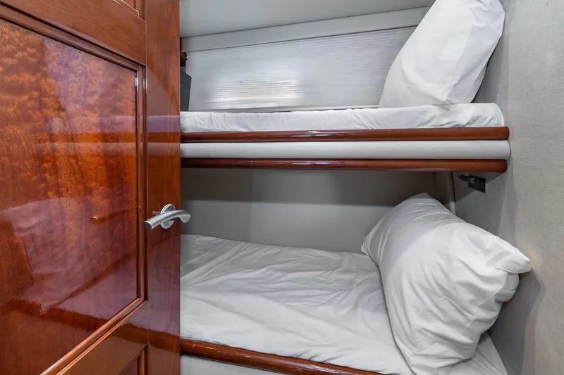  Yacht Photos Pics Bunk beds in 2005 Marquis 59 yacht cabin with wooden door and white bedding.