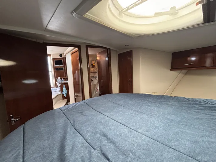 Sea Questah Yacht Photos Pics Interior of 2007 Carver 35 Super Sport yacht with cozy bedroom and wooden cabinetry.