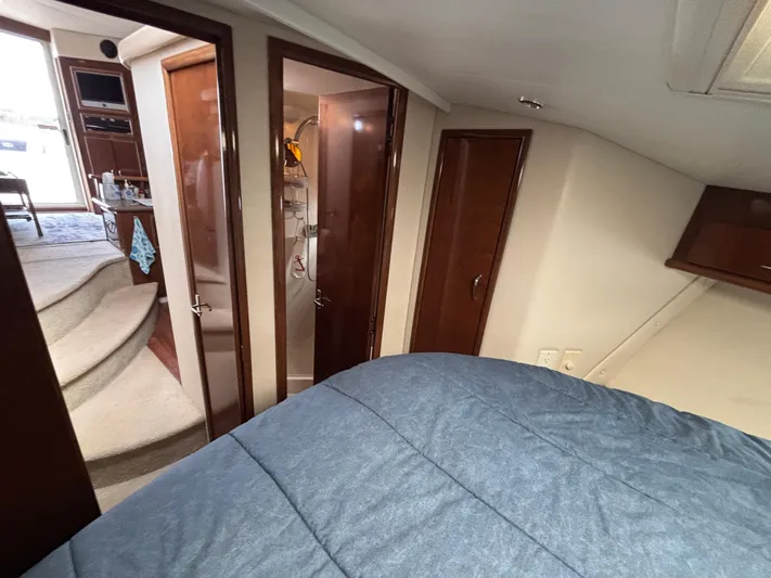 Sea Questah Yacht Photos Pics Interior of 2007 Carver 35 Super Sport yacht with cozy bedroom and wooden cabinetry.