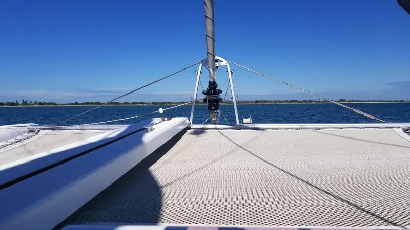 The Next Thing Yacht Photos Pics Catamaran deck view on water, Lagoon 400 owner's version, 2010 model, under clear blue sky.