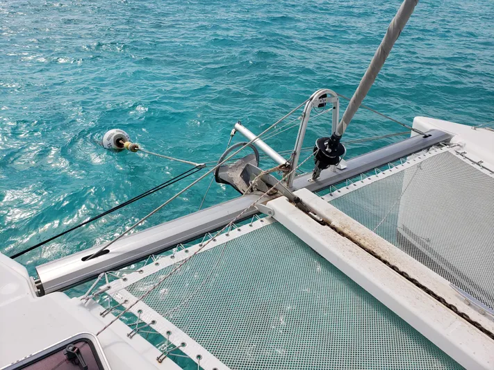 The Next Thing Yacht Photos Pics Lagoon 400 catamaran bow with netting, 2010 model, on clear turquoise water.