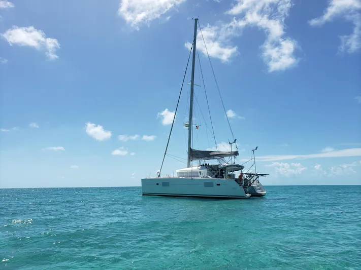 The Next Thing Yacht Photos Pics 2010 Lagoon 400 owner's version catamaran sailing on clear blue ocean under sunny sky.