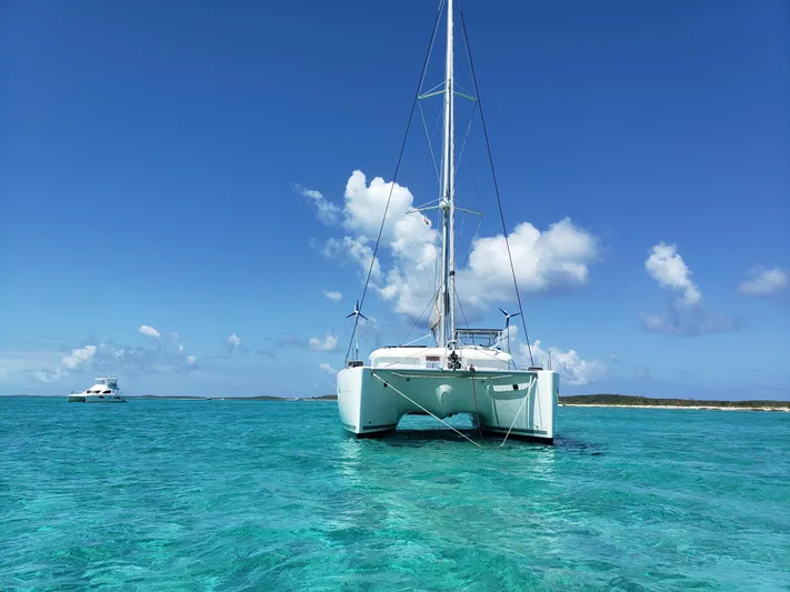 The Next Thing Yacht Photos Pics Lagoon 400 catamaran anchored in clear turquoise waters under a bright blue sky.
