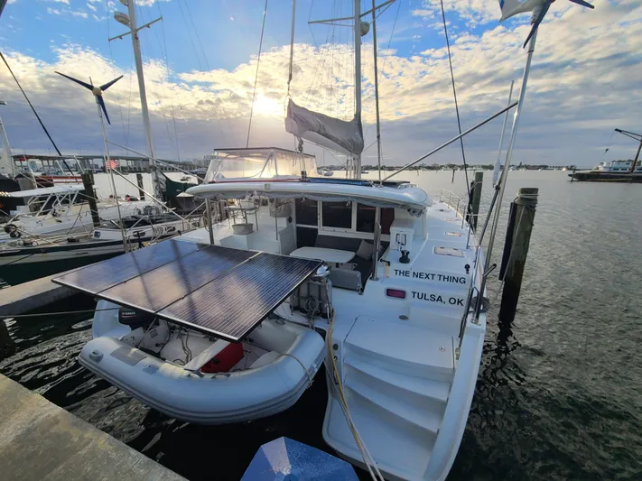 The Next Thing Yacht Photos Pics 2010 Lagoon 400 owner's version catamaran docked with solar panels and dinghy.