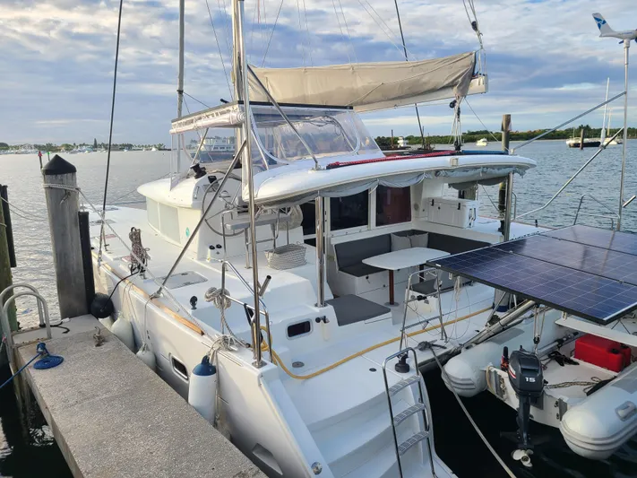 The Next Thing Yacht Photos Pics 2010 Lagoon 400 owner's version catamaran docked, featuring solar panels and spacious deck.