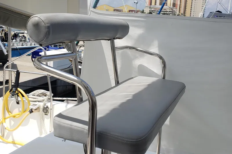The Next Thing Yacht Photos Pics Helm seat on 2010 Lagoon 400 owner's version catamaran, featuring stainless steel frame and gray cushions.