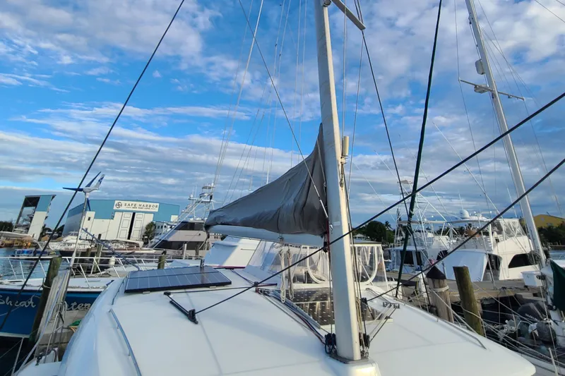 The Next Thing Yacht Photos Pics 2010 Lagoon 400 owner's version catamaran docked at marina under blue sky.