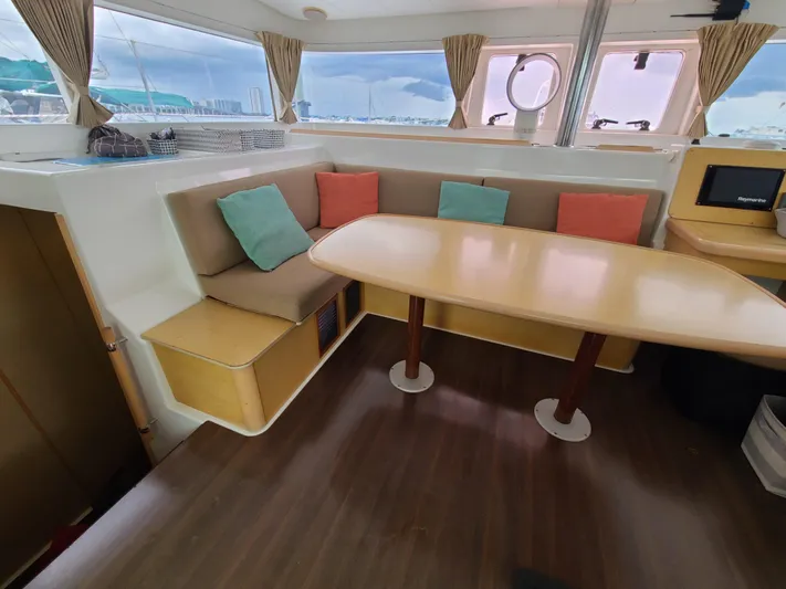 The Next Thing Yacht Photos Pics Interior of 2010 Lagoon 400 owner's version catamaran with dining area and colorful cushions.