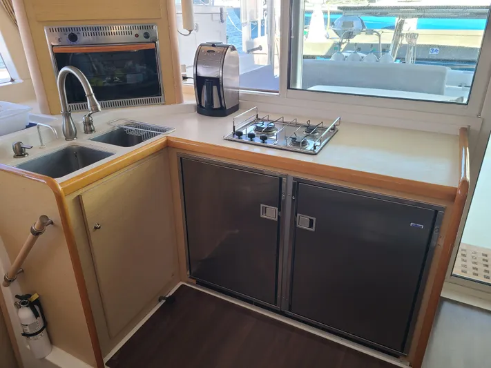 The Next Thing Yacht Photos Pics Modern kitchen in 2010 Lagoon 400 yacht with stove, sink, and appliances.