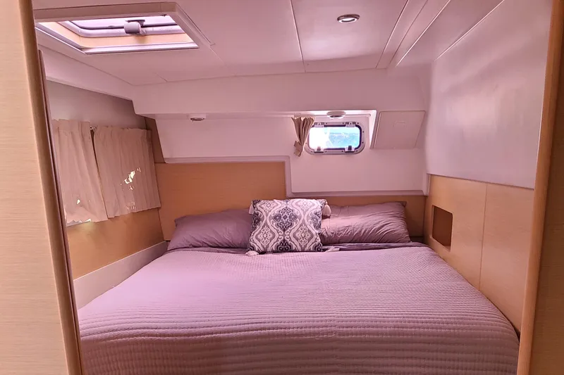 The Next Thing Yacht Photos Pics Cozy bedroom in 2010 Lagoon 400 owner's version catamaran with skylight and window.