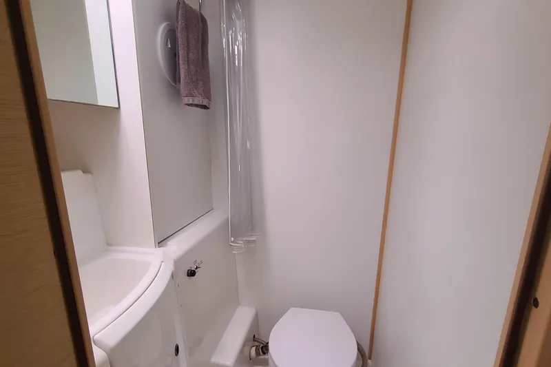 The Next Thing Yacht Photos Pics Bathroom interior of 2010 Lagoon 400 owner's version catamaran, featuring sink and toilet.