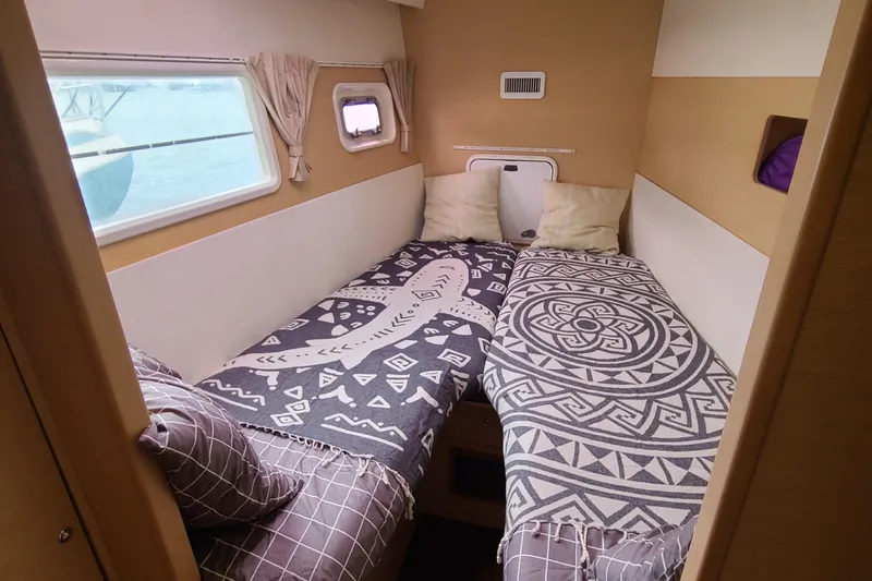The Next Thing Yacht Photos Pics Cozy cabin interior of 2010 Lagoon 400 owner's version with twin beds and patterned bedding.