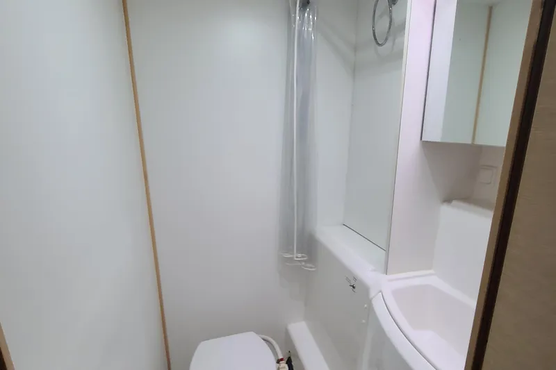 The Next Thing Yacht Photos Pics Bathroom interior of 2010 Lagoon 400 owner's version catamaran, featuring toilet and shower.