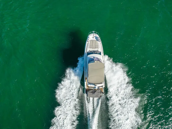 Living Out Loud Yacht Photos Pics Aerial view of 2020 Prestige 420 yacht cruising on turquoise water.