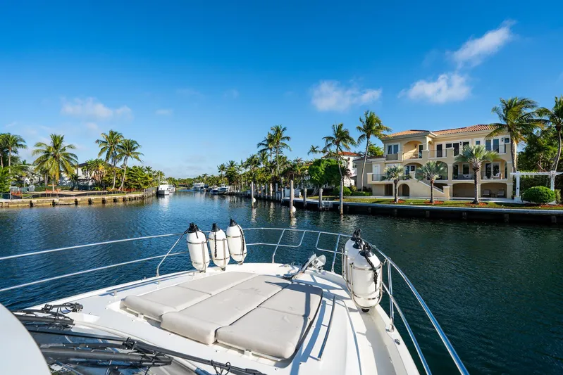 Living Out Loud Yacht Photos Pics Prestige 420 yacht cruising through a scenic canal with luxury homes and palm trees.
