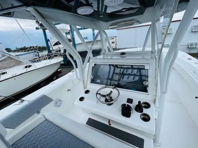  Yacht Photos Pics 2020 SeaHunter 39 Tournament boat cockpit with steering wheel and controls, docked near other boats.