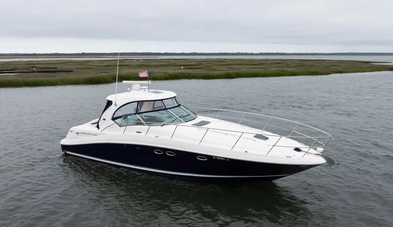 Sarah Jane III Yacht Photos Pics 2005 Sea Ray 390 Sundancer yacht cruising on calm waters near a grassy shoreline.