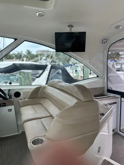 Gorgeous Yacht Photos Pics Interior of a 2015 Formula 45 Yacht with beige seating and mounted TV.
