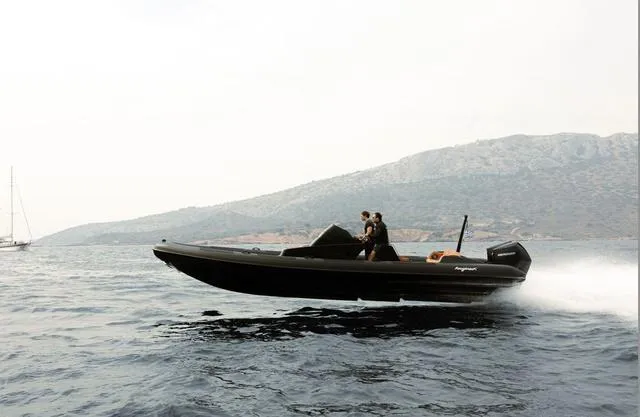  Yacht Photos Pics Roughneck RIB 1010 boat cruising on water, 2022 model, with mountainous background.