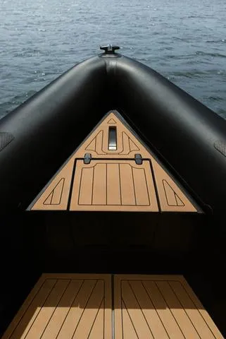  Yacht Photos Pics Roughneck RIB 1010 boat, 2022 model, featuring a sleek black and wood design on water.