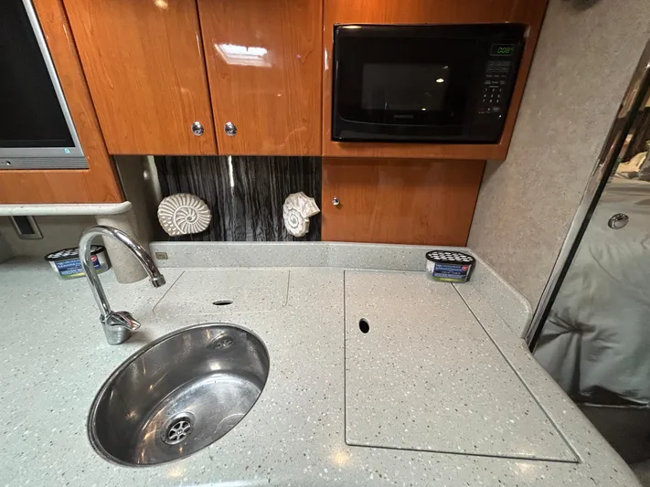  Yacht Photos Pics 2005 Formula 37 PC yacht kitchen with sink, microwave, and wooden cabinets.