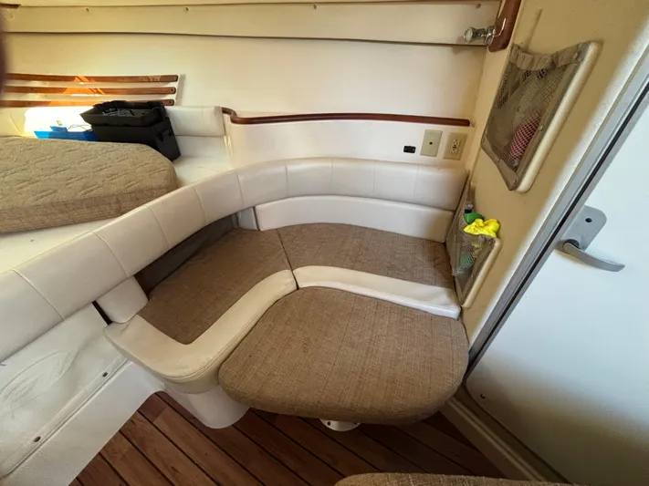 Kahuna Yacht Photos Pics 2002 Grady-White Express 330 cabin interior with cushioned seating and wooden flooring.