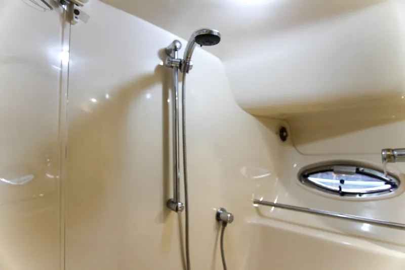 Pal'party Yacht Photos Pics Shower area in 2000 Sea Ray 450 Express Bridge yacht, featuring chrome fixtures and porthole window.