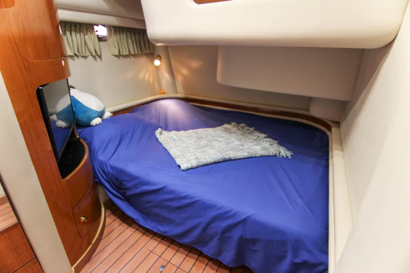 Pal'party Yacht Photos Pics Cozy cabin interior of 2000 Sea Ray 450 Express Bridge with blue bedding and wooden accents.