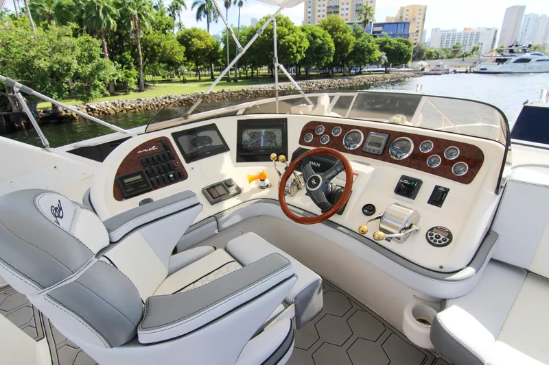 Pal'party Yacht Photos Pics Helm of 2000 Sea Ray 450 Express Bridge yacht with modern controls and scenic waterfront view.